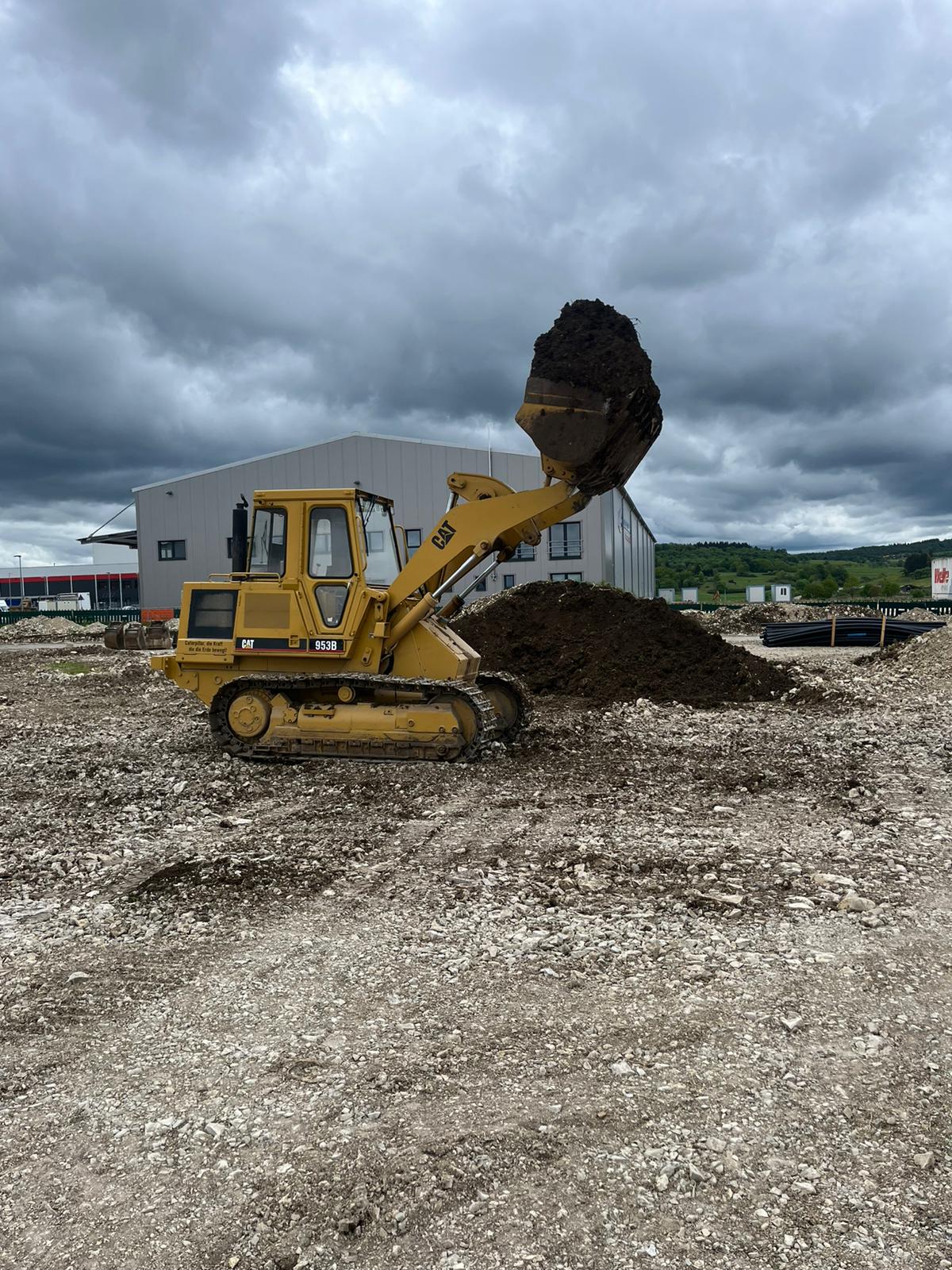Laderaupe Caterpillar 953B beim Aufnehmen von Mutterboden