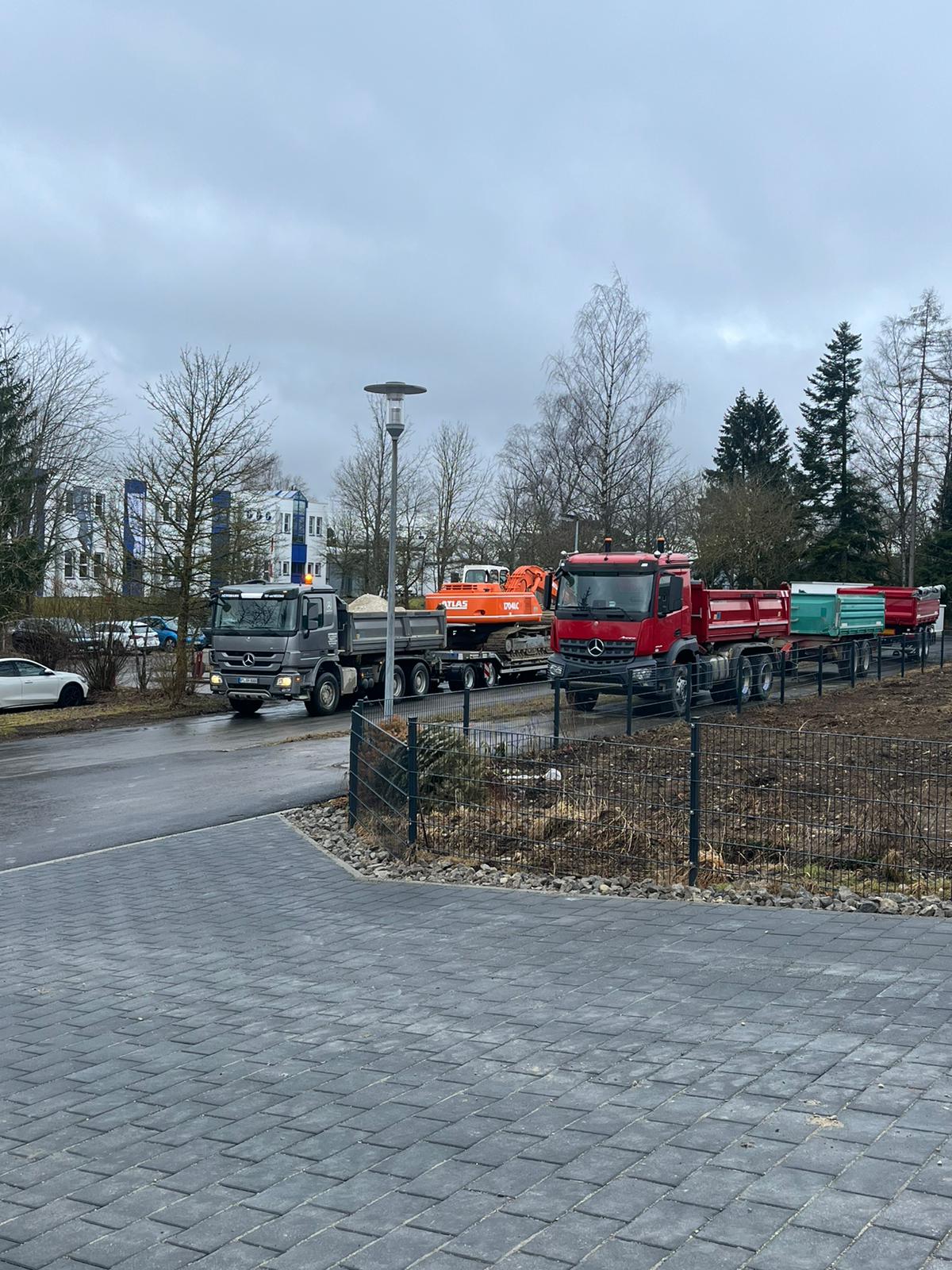 Kipper und Tieflader mit Kettenbagger auf dem Weg zur Baustelle